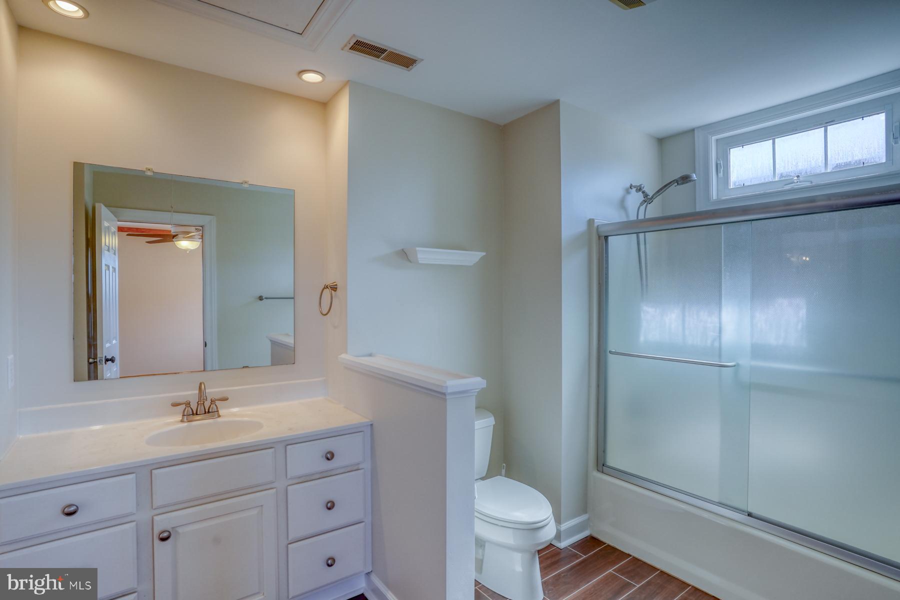 18605 Road 255 Georgetown, DE 19947 - Photo 60 of 93 a bathroom with a toilet a sink a mirror and a shower