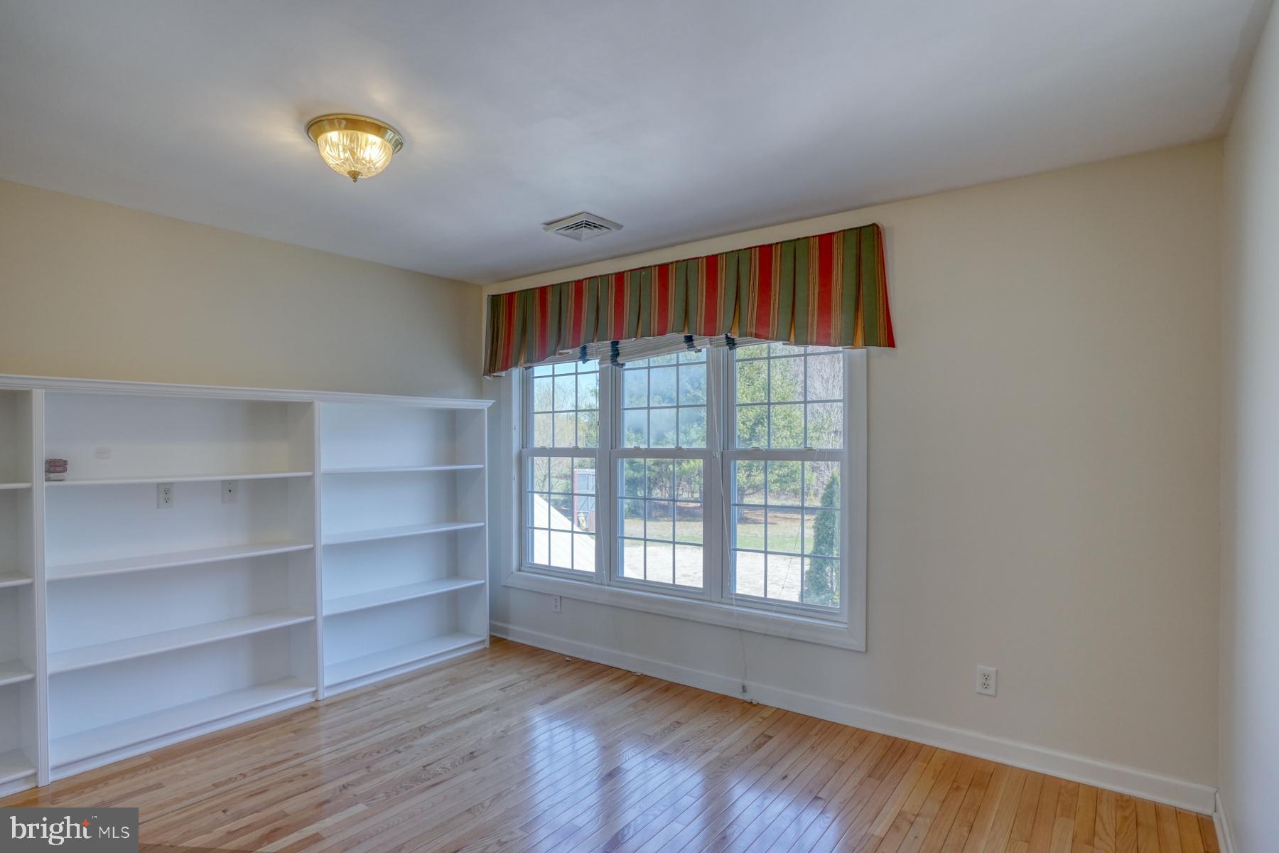 18605 Road 255 Georgetown, DE 19947 - Photo 66 of 93 a view of an empty room with a window and wooden floor