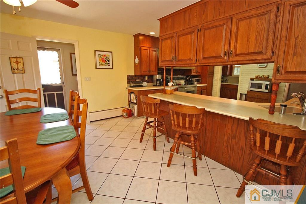 40 Stafford Road Colonia, NJ 07067 - Photo 18 of 25 a open kitchen with stainless steel appliances granite countertop a stove a sink a dining table and chairs with the view of living room