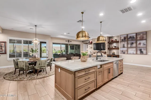 a kitchen with stainless steel appliances granite countertop a lot of cabinets and wooden floor