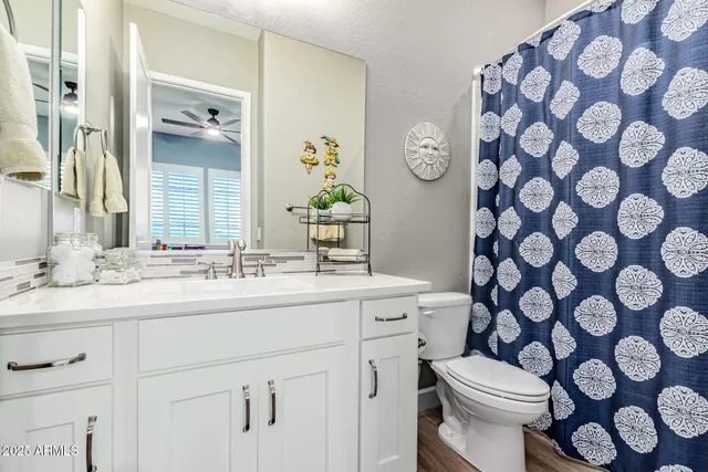 a large bed sitting in a bedroom next to a window and a chandelier