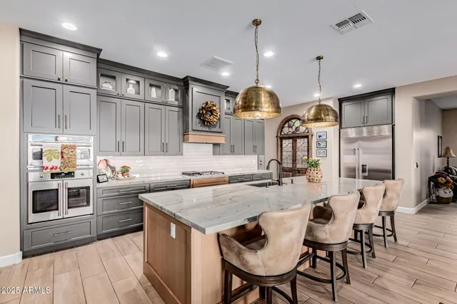 a kitchen with stainless steel appliances granite countertop a stove a sink a oven a dining table and chairs