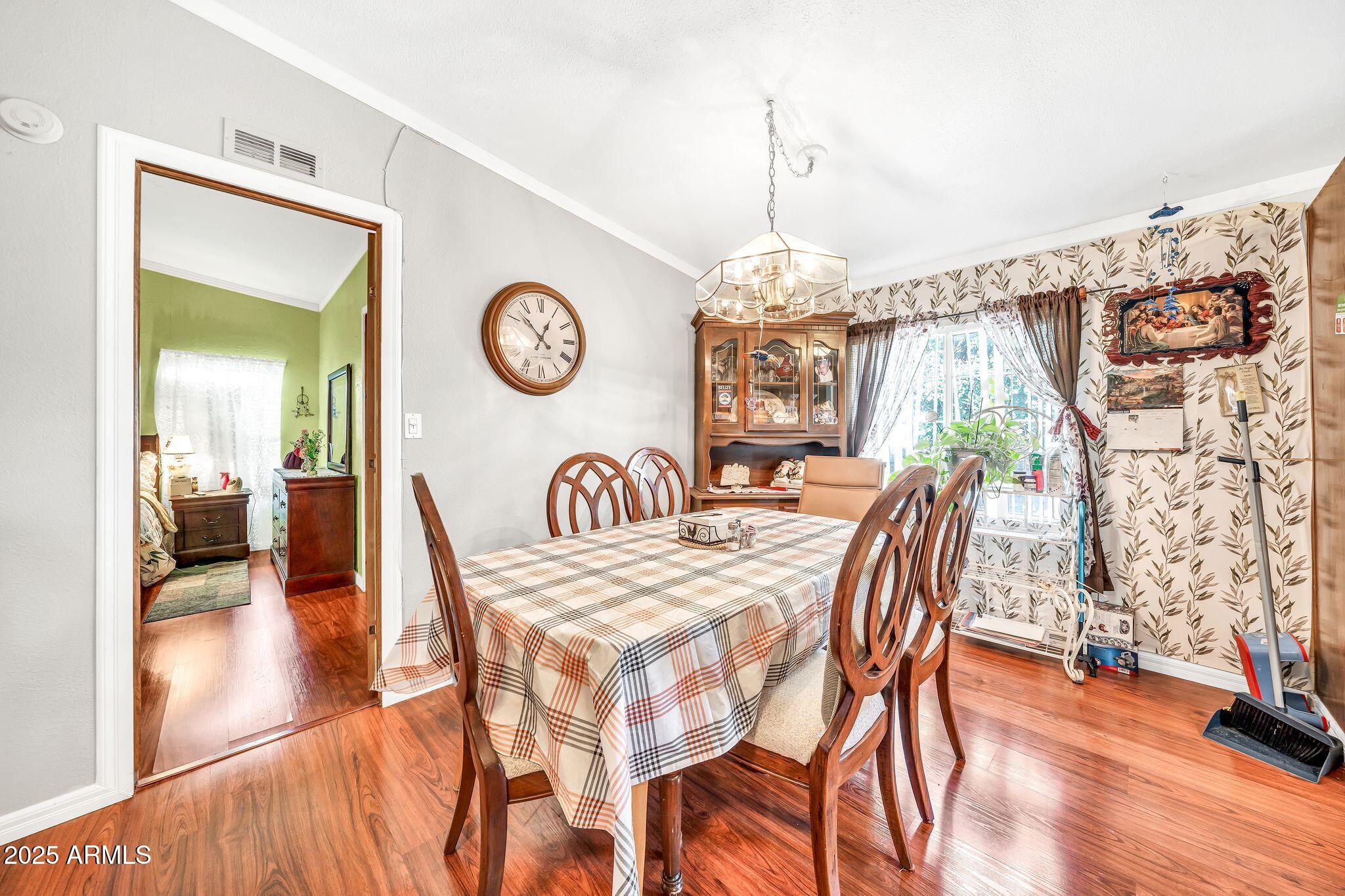 2510 East Utopia Road Phoenix, AZ 85050 - Photo 13 of 31 a view of a dining room and livingroom with furniture wooden floor a chandelier