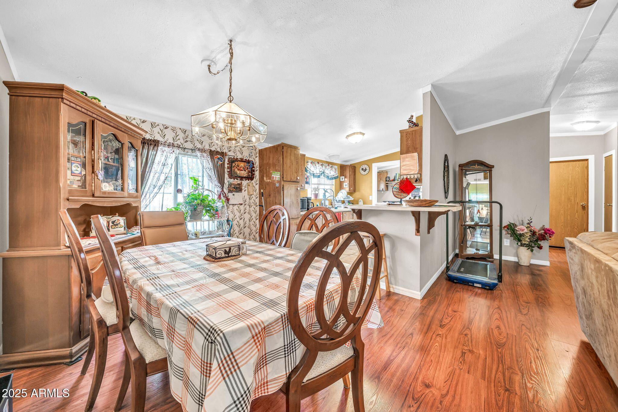 2510 East Utopia Road Phoenix, AZ 85050 - Photo 14 of 31 a view of a dining room with furniture a chandelier and wooden floor