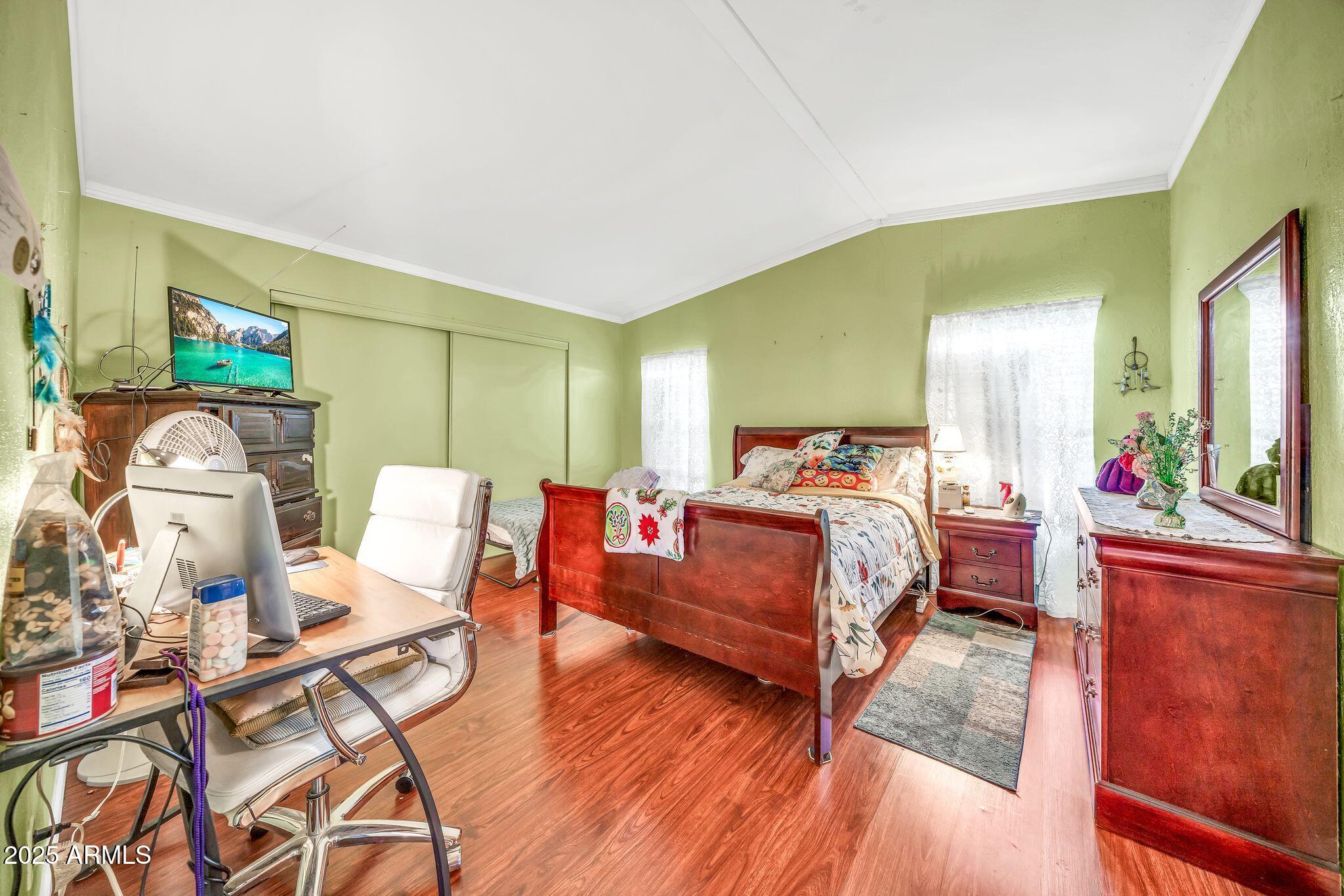 2510 East Utopia Road Phoenix, AZ 85050 - Photo 16 of 31 a bedroom with a bed and wooden floor