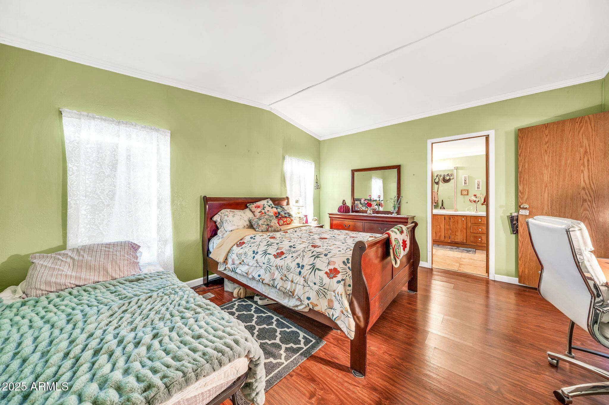 2510 East Utopia Road Phoenix, AZ 85050 - Photo 17 of 31 a bedroom with a bed and wooden floor