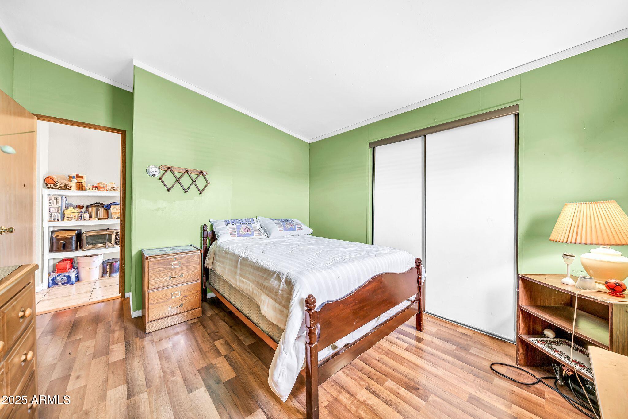 2510 East Utopia Road Phoenix, AZ 85050 - Photo 20 of 31 a bedroom with a bed and a wooden floor