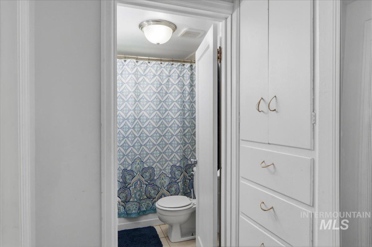 1958 East 1775 South Gooding, ID 83330 - Photo 25 of 49 White built-in cabinetry with gold-toned hardware offering storage, with a full bathroom visible beyond