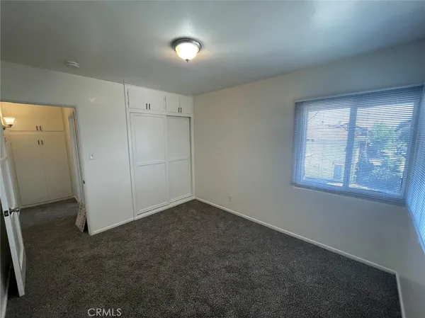 an empty room with windows and closet