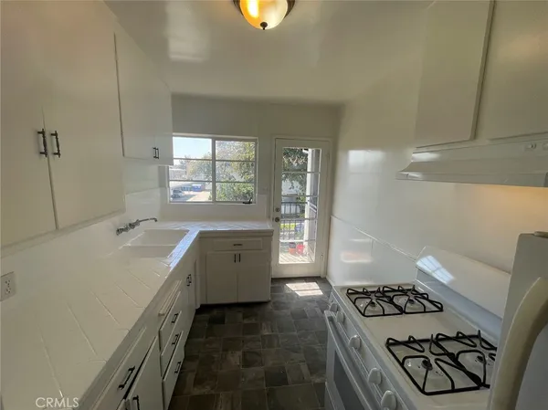a kitchen with sink stove and cabinets