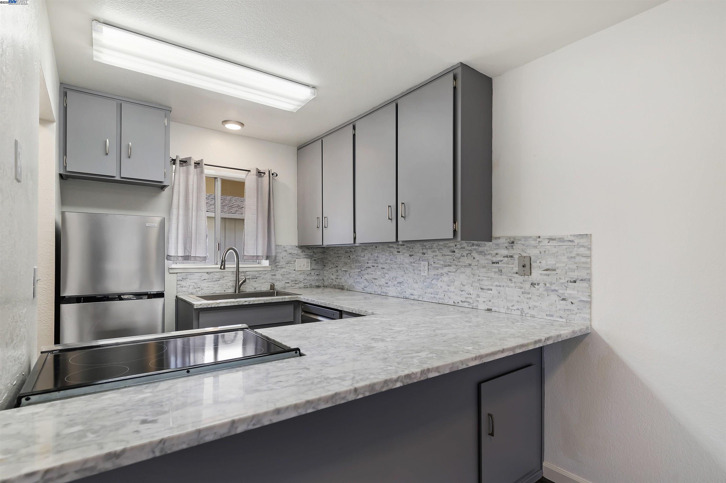3849 Vineyard Avenue, Unit B Pleasanton, CA 94566 - Photo 8 of 21 a kitchen with stainless steel appliances granite countertop a sink and a refrigerator