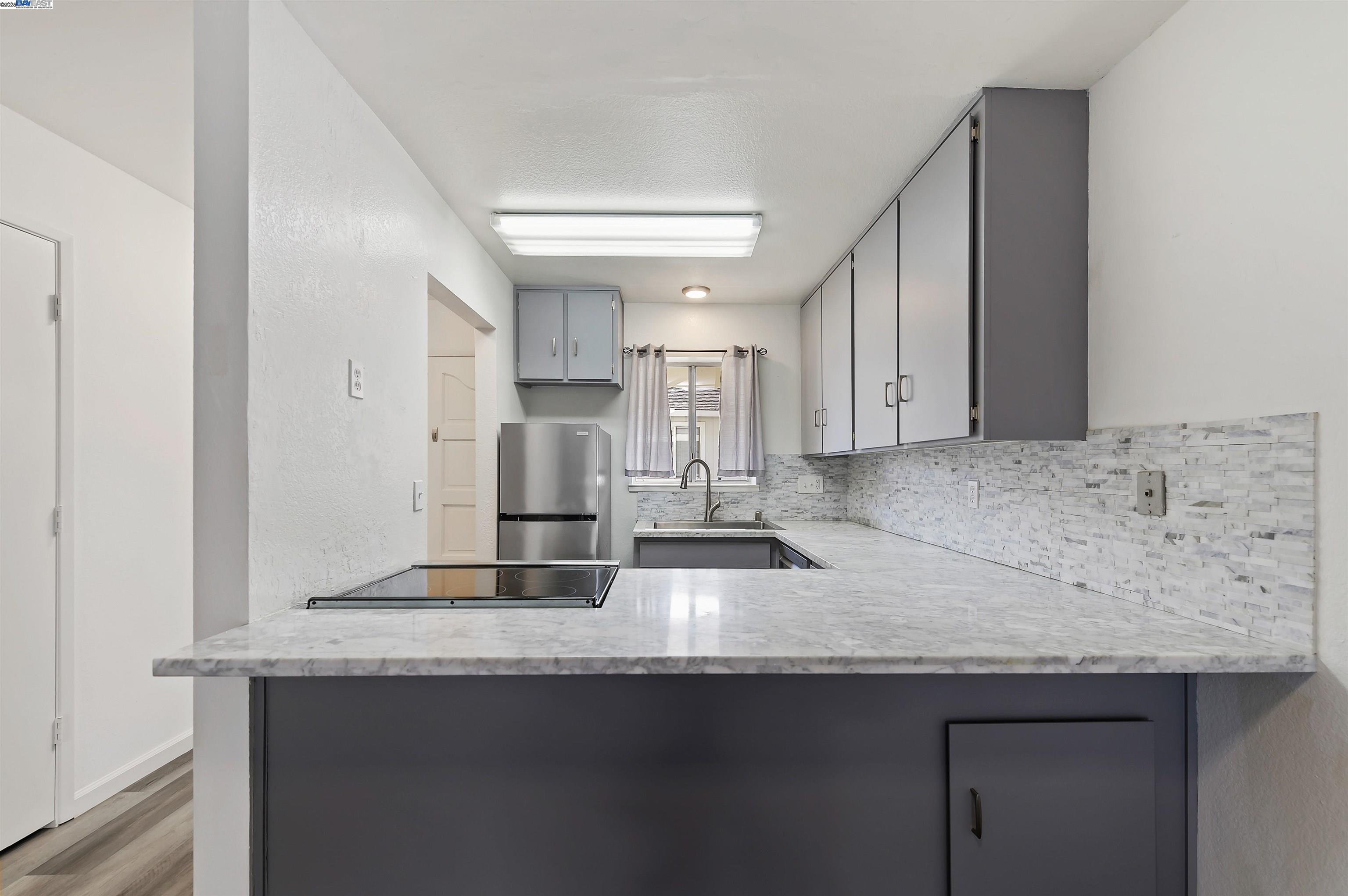 3849 Vineyard Avenue, Unit B Pleasanton, CA 94566 - Photo 9 of 21 a kitchen with stainless steel appliances granite countertop a sink and a refrigerator