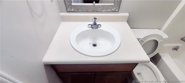 a bathroom with a sink mirror and toilet