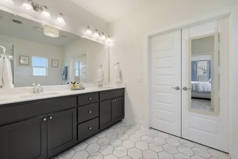 a bathroom with double sink and a mirror