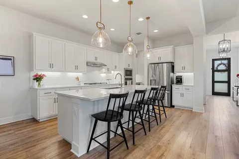a kitchen with kitchen island white cabinets and stainless steel appliances