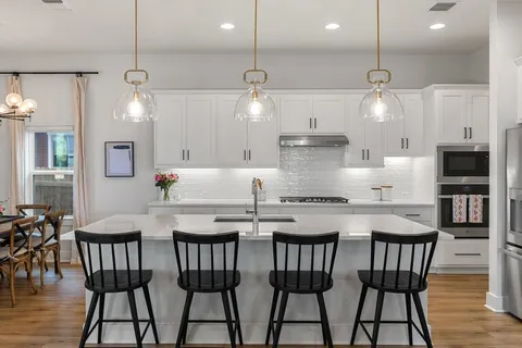 a kitchen with stainless steel appliances kitchen island a chandelier