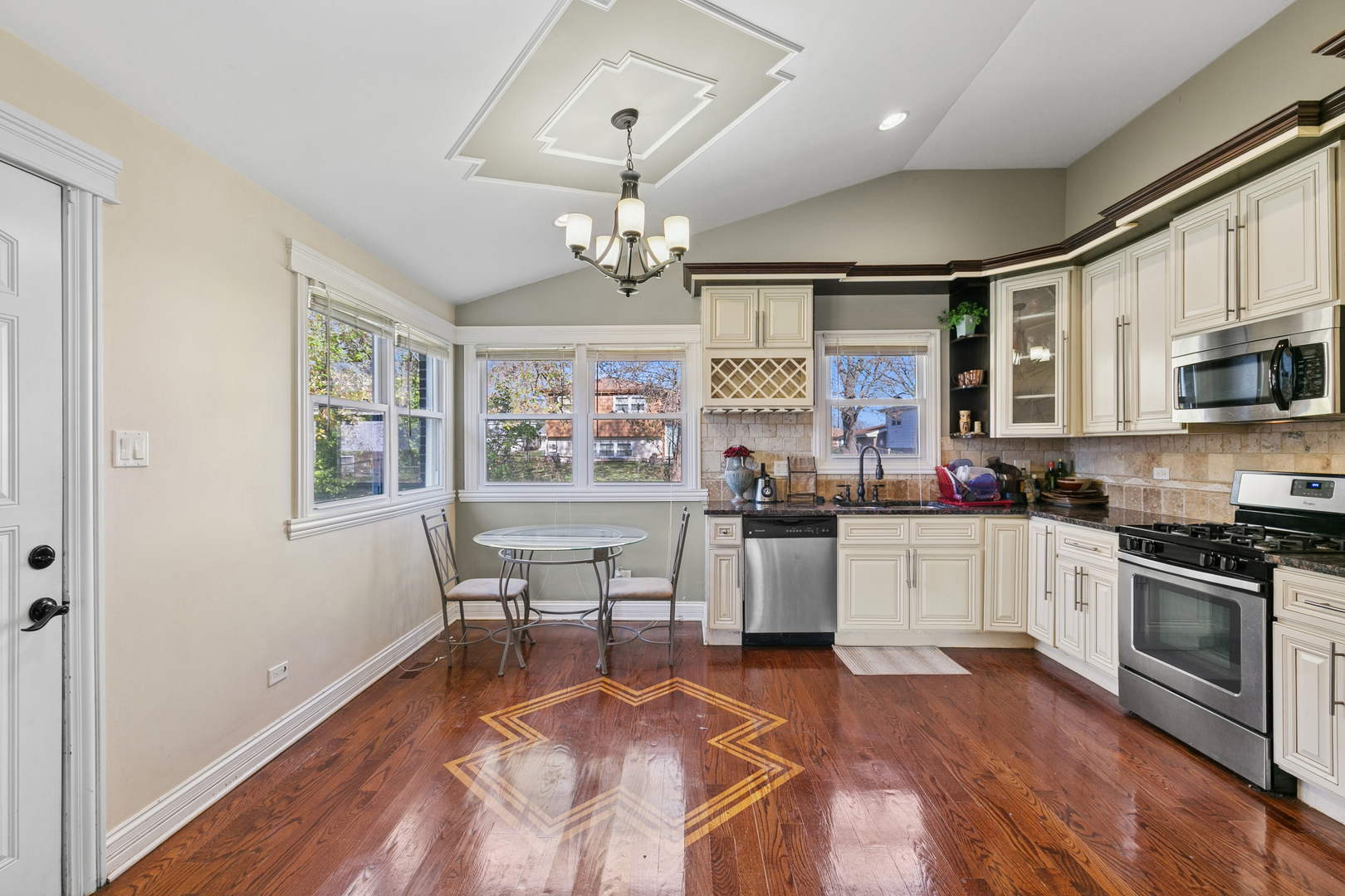 6306 Beaver Dam Road Matteson, IL 60443 - Photo 6 of 20 a kitchen with stainless steel appliances granite countertop a stove top oven a sink dishwasher a dining table and chairs with wooden floor