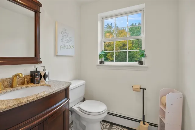a bathroom with a granite countertop sink toilet and a mirror