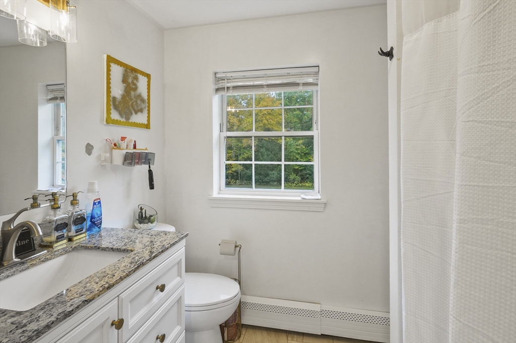 108 Royalston Road North Winchendon, MA 01475 - Photo 27 of 32 a bathroom with a granite countertop toilet a sink and a mirror