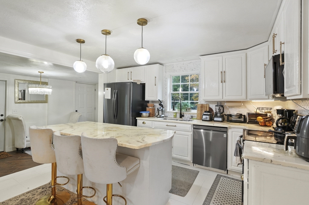 108 Royalston Road North Winchendon, MA 01475 - Photo 6 of 32 a kitchen with stainless steel appliances a stove a sink a refrigerator a center island a dining table and chairs