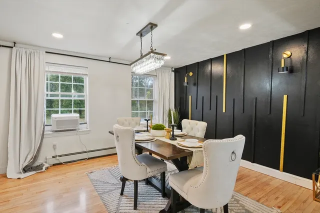 a dining room with furniture a chandelier and wooden floor