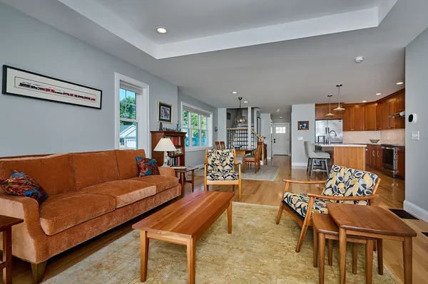 a living room with furniture and a dining table with kitchen view