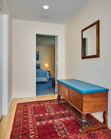 a bedroom with a bed and a lamp on dresser