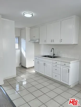 a kitchen with granite countertop white cabinets and stainless steel appliances