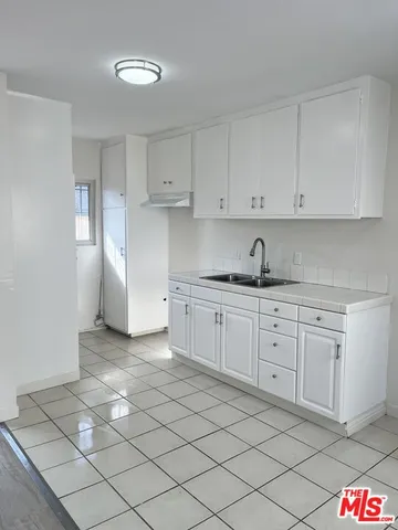 a kitchen with granite countertop white cabinets and stainless steel appliances