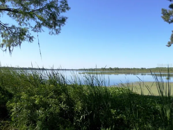 a view of lake with a big yard