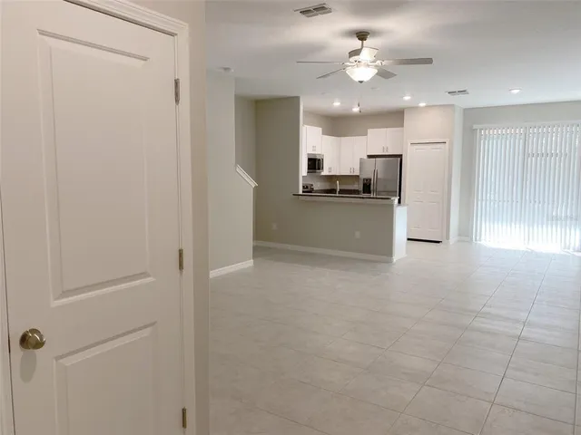 an empty room with chandelier fan