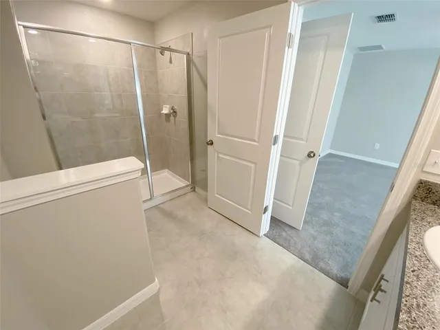 an empty room with a fan & a chandelier fan