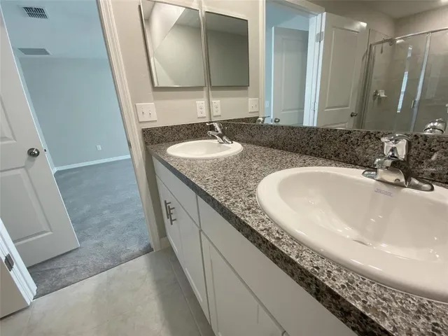 an empty room with chandelier fan and windows