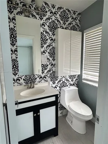 a bathroom with a sink toilet and mirror