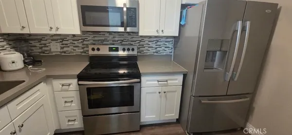 a kitchen with stainless steel appliances granite countertop a refrigerator and a stove