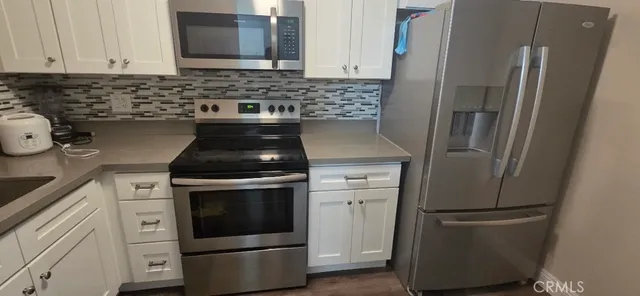 a kitchen with stainless steel appliances granite countertop a refrigerator and a stove