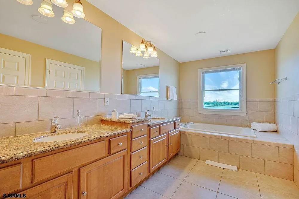 2140 West Riverside Drive Atlantic City, NJ 08401 - Photo 28 of 30 a bathroom with a granite countertop sink mirror bathtub and window