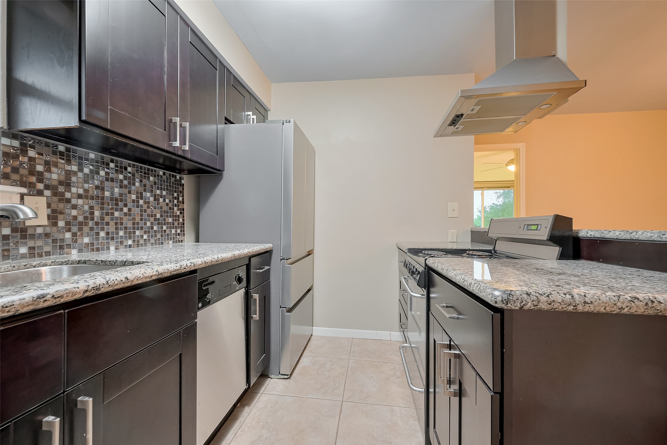 8019 Colgate Street Houston, TX 77061 - Photo 18 of 27 Galley kitchen arrangement with granite counters and modern exhaust fan.