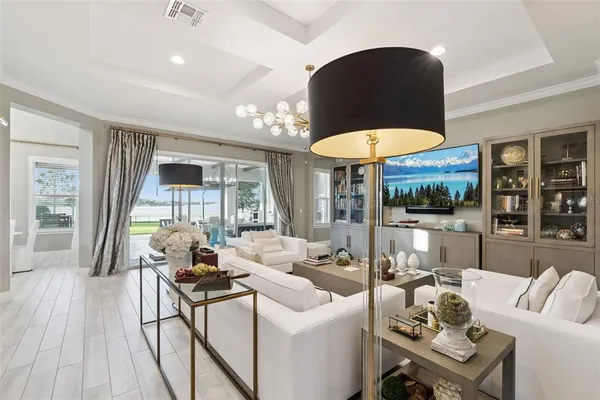 a view of a dining room and livingroom with furniture wooden floor a chandelier
