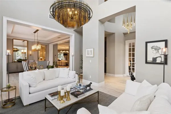 a dining room with furniture large windows and wooden floor