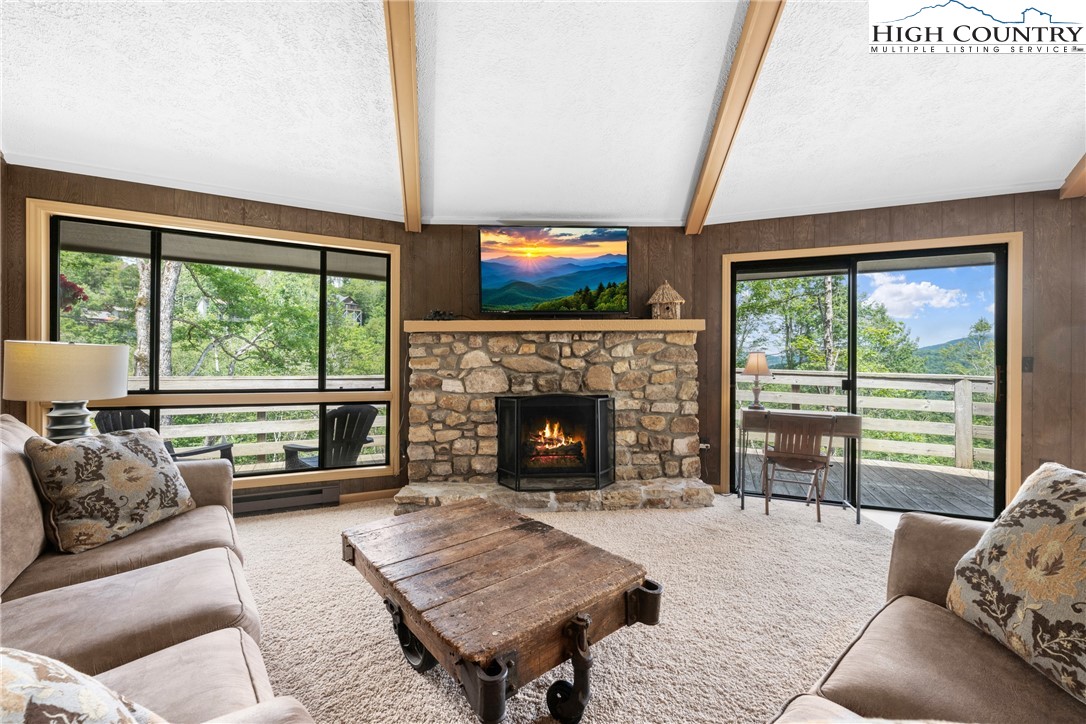 a living room with furniture large window and a fireplace