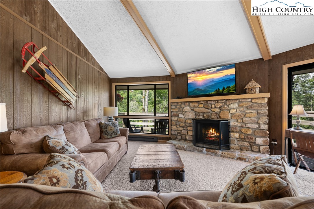 315 Timber Ridge Road, Unit A3 Sugar Mountain, NC 28604 - Photo 11 of 27 a living room with furniture a flat screen tv and a fireplace