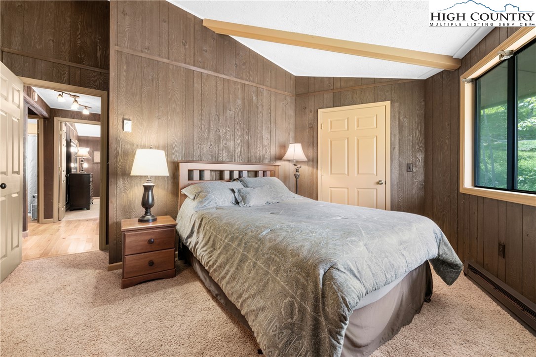 315 Timber Ridge Road, Unit A3 Sugar Mountain, NC 28604 - Photo 24 of 27 a bedroom with a bed a mirror and a large window