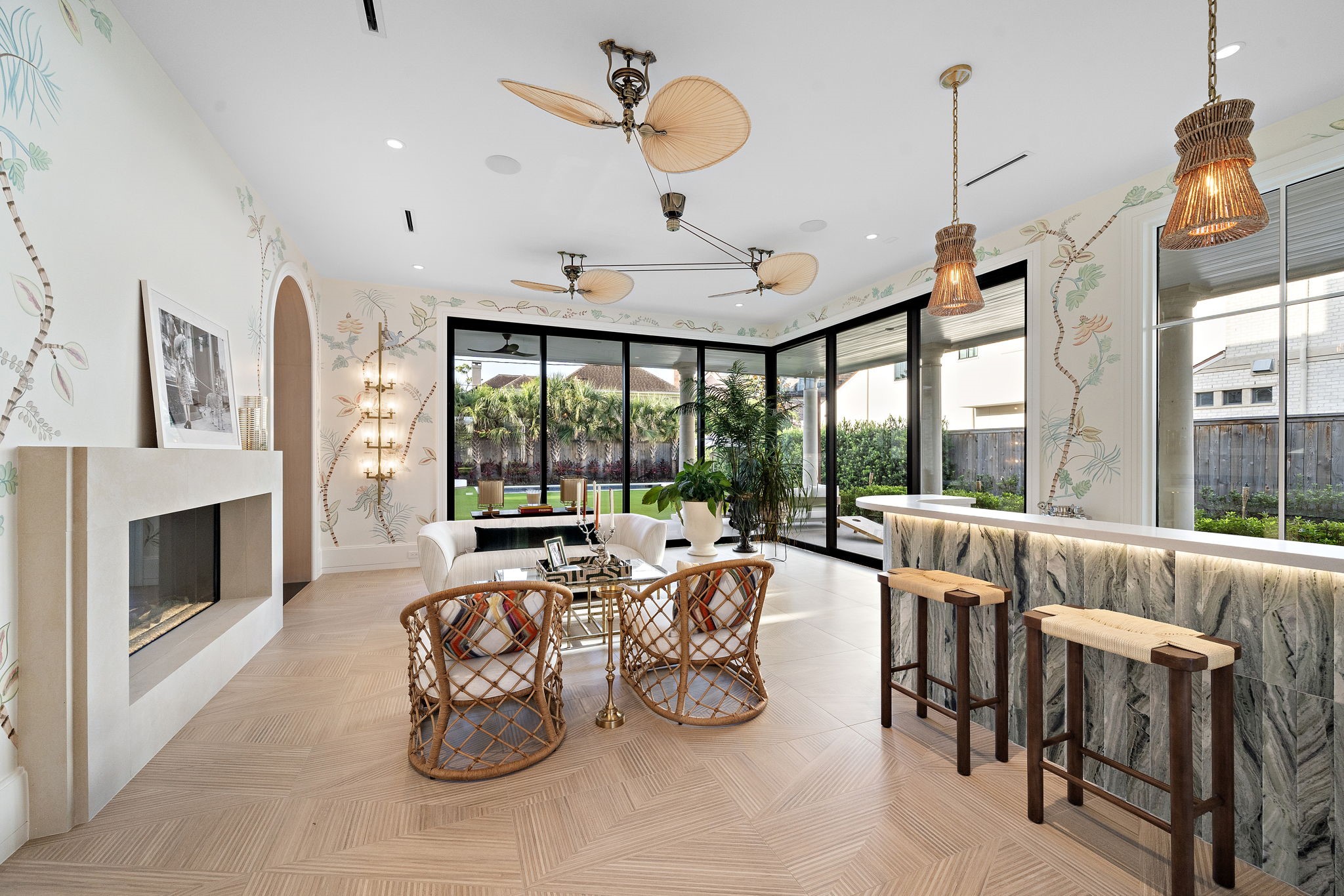 3649 Chevy Chase Drive Houston, TX 77019 - Photo 22 of 50 Seamless indoor-outdoor living unfolds in the sunroom with retractable glass doors. Tropical theme enhanced by a hand-painted mural, 8' cast stone fireplace, and custom bar.