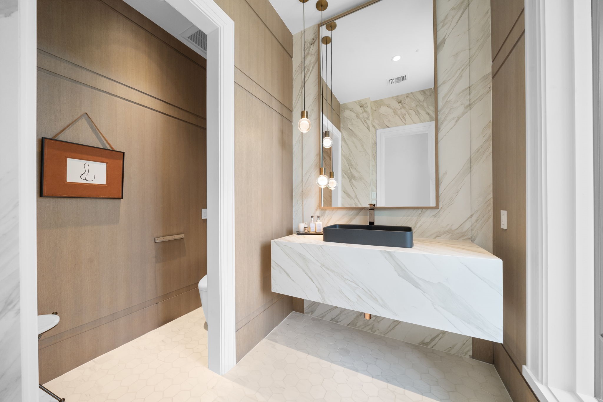 3649 Chevy Chase Drive Houston, TX 77019 - Photo 25 of 50 One of the first-floor power baths crafted to leave a lasting impression. Clad in Neolith Calacatta Gold stone with a sculptural floating vanity, visual comfort pendant lighting and Toto washlet.