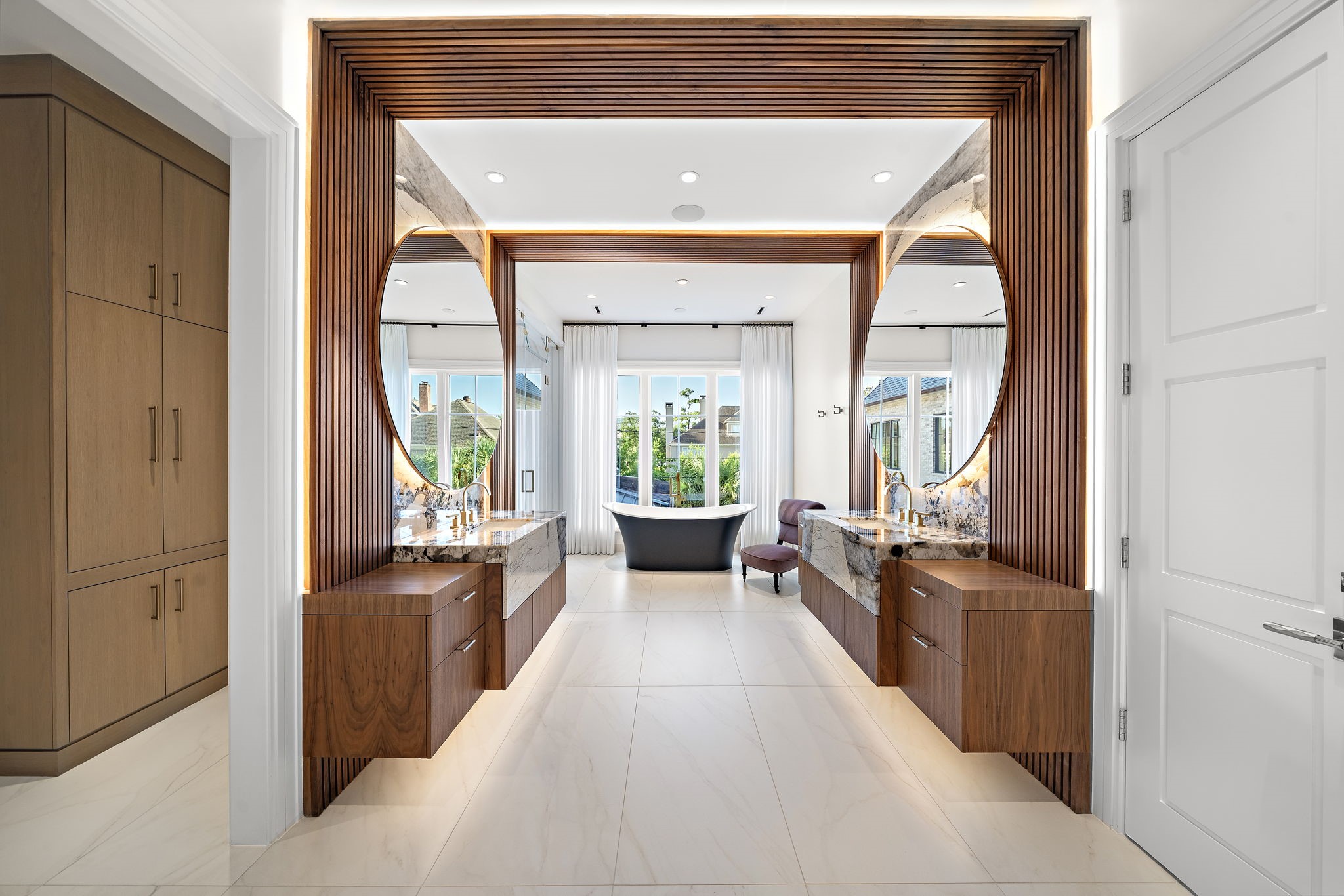 3649 Chevy Chase Drive Houston, TX 77019 - Photo 31 of 50 A spa-inspired retreat featuring fluted wood walls and ceiling detail, warm walnut cabinetry, and a sculptural Victoria + Albert soaking tub as the centerpiece. Boutique-style dressing rooms and dual water closets complete this luxurious and thoughtfully designed space.