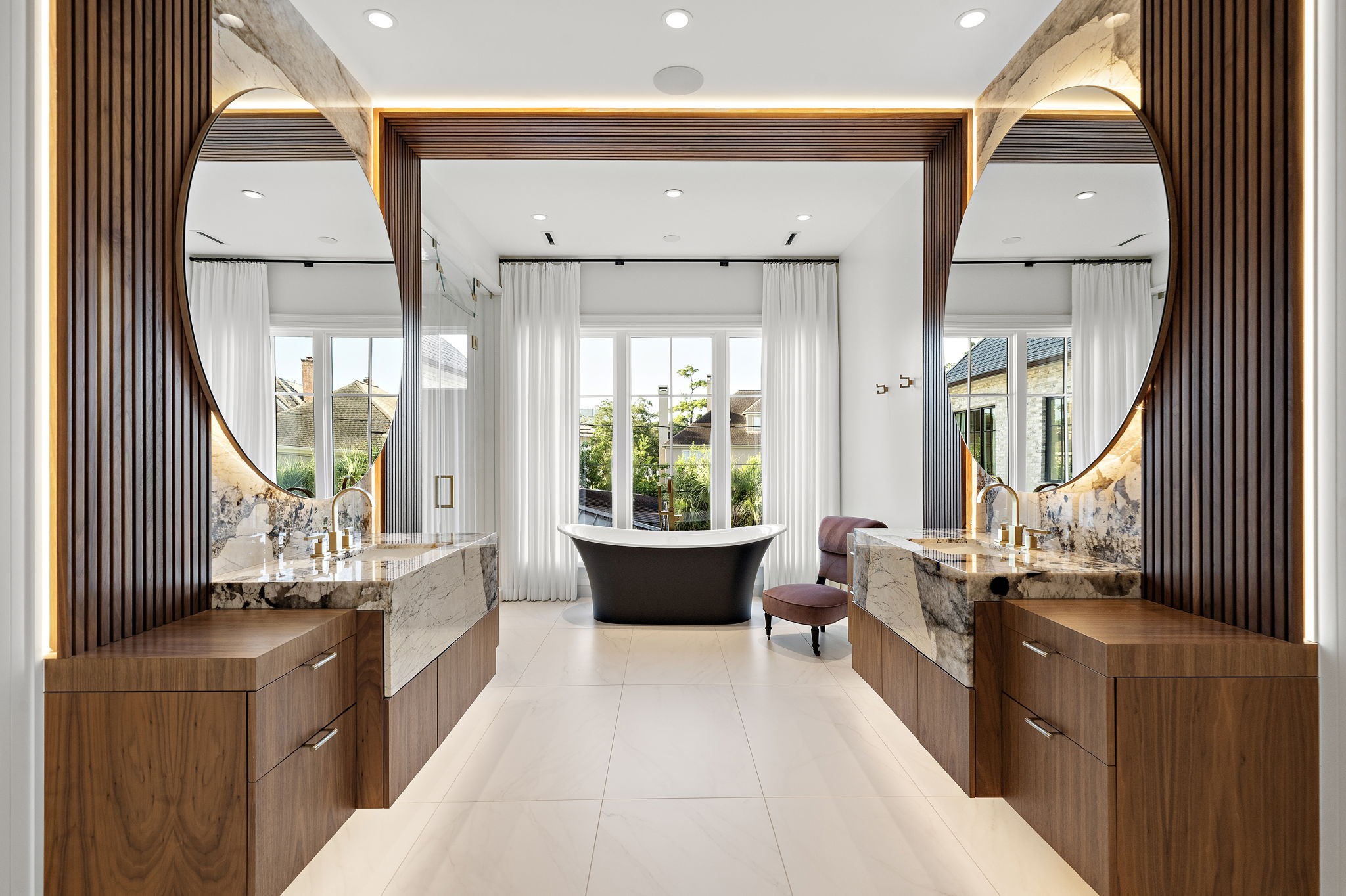 3649 Chevy Chase Drive Houston, TX 77019 - Photo 8 of 50 An exquisite primary bath with fluted wood feature walls, floating cabinetry, and dual vanities crowned in Cristallo Fire Quartzite. A sculptural soaking tub, dual water closets, and separate boutique-inspired dressing rooms complete this serene escape.