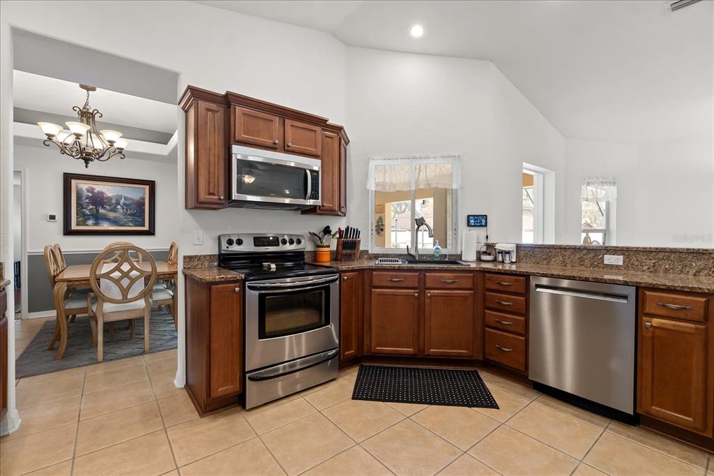 1254 Timberidge Loop South Lakeland, FL 33809 - Photo 12 of 36 a kitchen with stainless steel appliances granite countertop a stove top oven a sink dishwasher and a microwave oven on the blue kitchen countertops