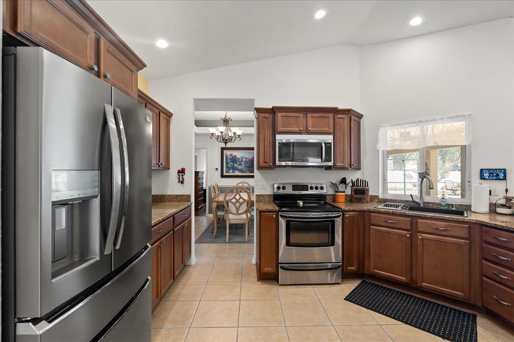 1254 Timberidge Loop South Lakeland, FL 33809 - Photo 13 of 36 a kitchen with granite countertop a refrigerator stove and sink