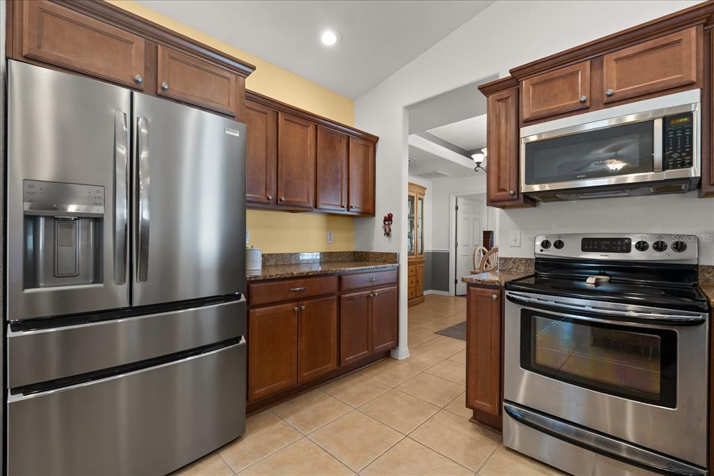 1254 Timberidge Loop South Lakeland, FL 33809 - Photo 14 of 36 a kitchen with granite countertop stainless steel appliances and wooden cabinets